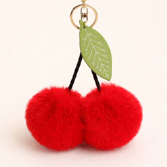 Red fluffy cherry keychain with a green leaf