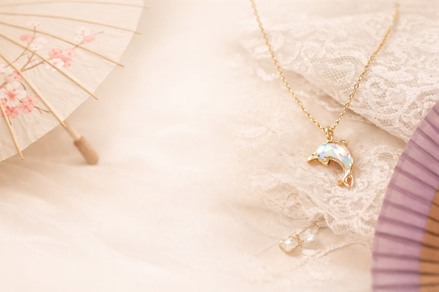 Necklace with a dolphin pendant on a soft pink background